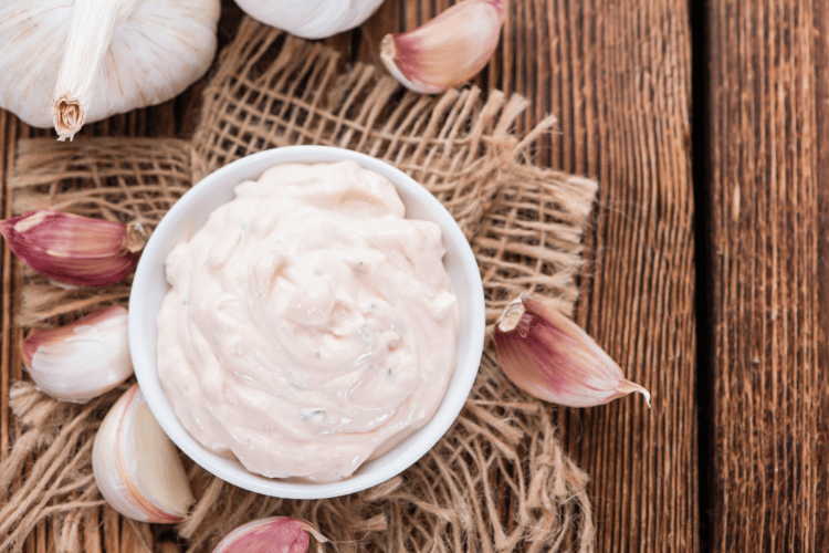 Top view of garlic an aioli on a wooden kitchen table