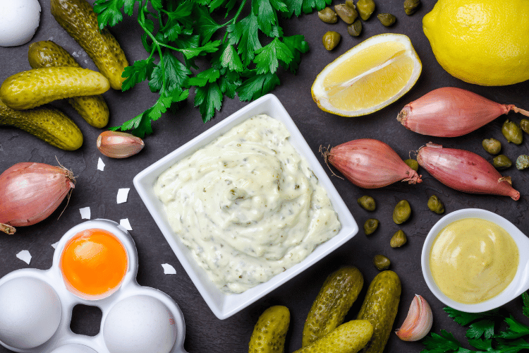 Traditional French sauce remoulade in a white bowl with ingredients