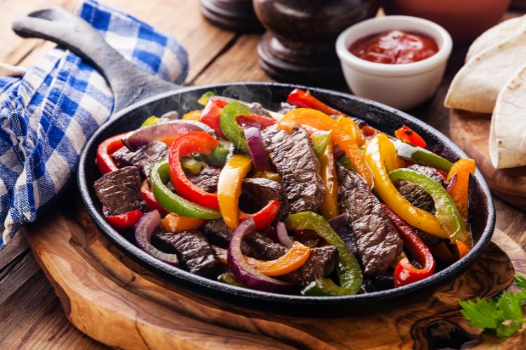 Beef Fajitas with colorful bell peppers, tortilla bread and sauces