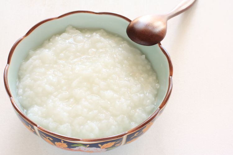 Rice porridge in a bowl with wooden spoon